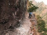 Manaslu 02 07 Dangerous Trail The trail climbs onto a ridge above huge rapids on the Buri Gandaki. Much of the trail is blasted out of vertical rock walls - steady on your feet and don't look down while youre climbing the stone steps cut out of the mountainside. We arrived at the Gurung village of Labubesi (880m) at 15:00. A Maoist arrived at 17:30! She was a young, very mannerly, and soft-spoken young woman. She said she was collecting a 100 rupee per day tax for the Maoist Government. I dutifully paid her 1600 rupees and she gave me a receipt. She also asked for a donation. I refused, and she left.